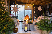 Weihnachtlich geschmücktes Zimmer mit Tannenbäumen, Kerzen und Sternen