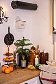 Kitchen corner with fruit, candles and kitchen utensils in clay pots