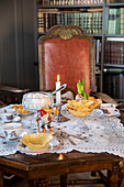 Elegant afternoon tea with biscuits and candles on an old wooden table