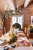 Rustic dining table with Christmas decorations, chandelier and natural materials