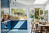 Bright country-style kitchen with blue cupboards and dining area