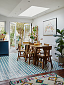 Bright dining room with skylight, colourful tiled floor and wooden furniture