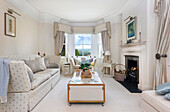 Elegant living room with fireplace and large window overlooking the greenery