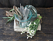Old cutlery in a glass and bouquet of snowdrops