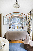 Bedroom in a tiny home with floral patterned wallpaper and curtains