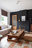 Living room with rustic wooden coffee table and fireplace with dark wall paneling