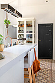 Modern kitchen with white display cabinet and patterned floor tiles