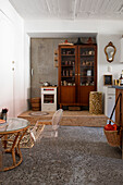 Retro kitchen with display cabinet, glass rattan table and unusual concrete floor