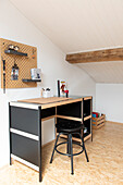 Schreibtisch mit schwarzem Hocker und Wandorganizer im Dachgeschosszimmer