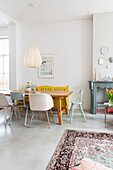 Dining table with chairs and vintage carpet in a bright dining room