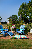 Blue garden chairs with colorful cushions on a lawn in summer