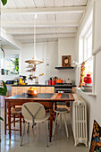 Country-style kitchen with white wooden ceiling and dining area