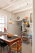 Country-style kitchen with wooden ceiling and metal shelving