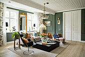 Living room with patterned curtains, crystal chandelier and light-colored wooden floor