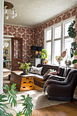 Living room with Chesterfield sofa, leather armchair and wallpaper