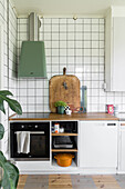 Kitchen unit with wooden worktop, green extractor fan and white tiles