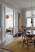 Dining room with wooden table, teak chairs and view into the living room