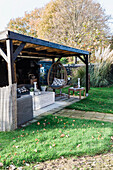 Covered seating area with hanging chair in the autumn garden