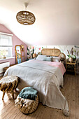 Schlafzimmer mit Rattanbett und Wandanstrich in Pastelltönen