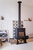 Freestanding wood-burning stove in front of a wall with decorative elements