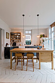 Bright kitchen with island, wooden bar stools and pendant lights