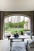 Gemütlicher Sitzbereich mit Blick auf den Garten durch ein großes Bogenfenster