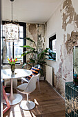 Dining area with vintage flair, chipped wall and modern chairs