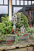 Winter decoration with coniferous branches, berries and wooden model houses