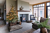 Wohnzimmer mit bodentiefen Fenstern, Kaminofen und Weihnachtsbaum