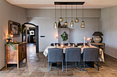 Dining table with grey chairs and pendant lights with a festive atmosphere