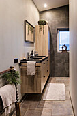 Modern bathroom with wooden accents and grey tiles