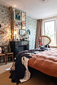 Bedroom with patterned wallpaper and decorative fireplace