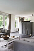 Bright living room in grey tones and view of the garden