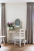 Dressing table with mirror and colourful bouquet of flowers in the bedroom