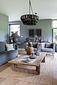 Wohnzimmer mit rustikalem Holztisch und grauen Sofas