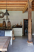 Offene Küche mit Holzbalken, Landhausstil und hängenden Industrielampen