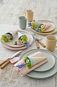 Spring table decoration with bouquets of flowers in paper cones