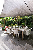 Patio dining area with wooden table, chairs and awning