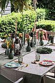 Laid garden table with candles, flowers and lanterns in summer