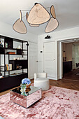 Modernes Wohnzimmer mit Sessel, Spiegel-Couchtisch und Draht-Pendelleuchten