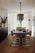 Dining area with black table, cantilever chairs and chandelier