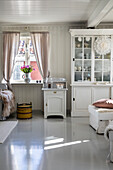 Hell eingerichtetes Wohnzimmer mit weißen Möbeln und Frühlingsblumen