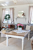 Bright country-style living room with coffee table and pink flowers