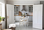 Country kitchen with white furnishings and dining table