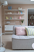 Bright living room with shelving system and pastel-colored decor