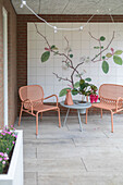 Modern terrace with mural and pink metal chairs