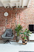 Armchair and houseplants in front of exposed brick wall in the living room