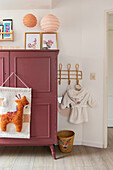 Children's room with red wardrobe and wall decoration