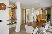 Modern dining room with wooden table, beige chairs and hanging lamps