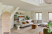 Spacious living area with light grey corner sofa and modern shelves